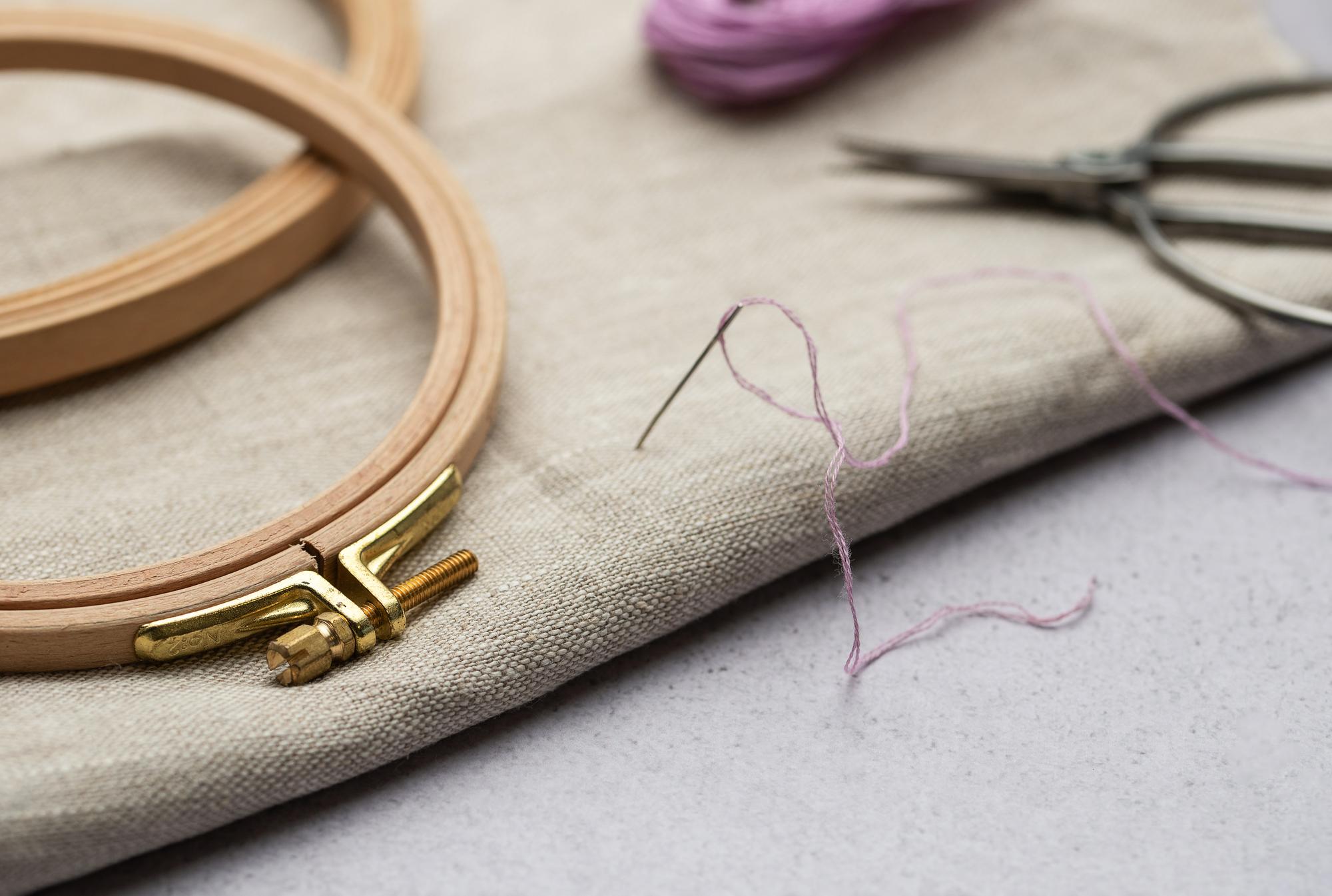 Hand bei der Stickarbeit mit Nadel und Faden